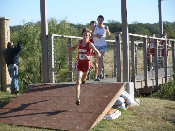 Dr. Stephens leading a cross country race down a wooden ramp