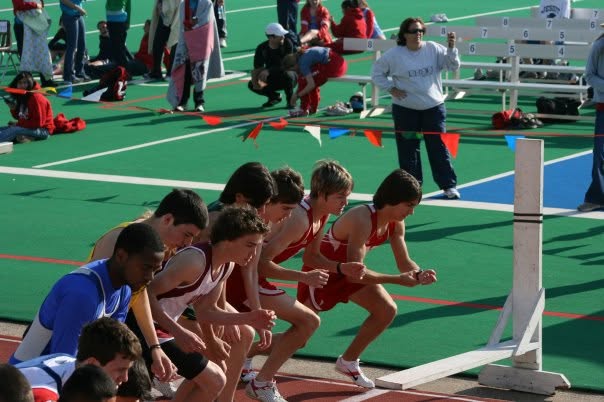 Dr. Stephens crouched at the start line of a track race with other runners